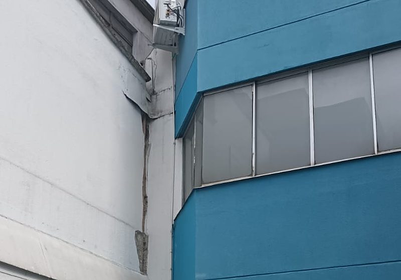 Fachada azul del Centro Médico Clínica Risaralda en Pereira y su junta dañada con el edificio vecino